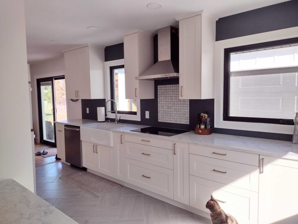 Contemporary kitchen with rich wood cabinets, gold hardware, and a patterned tile backsplash, created by a Mead Lumber designer, using Mead Lumber materials