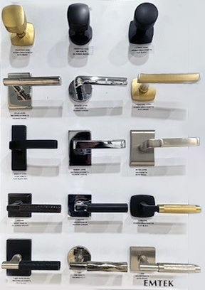 Door knobs and handles in black, silver, and gold on a display in Mead Lumber showroom.